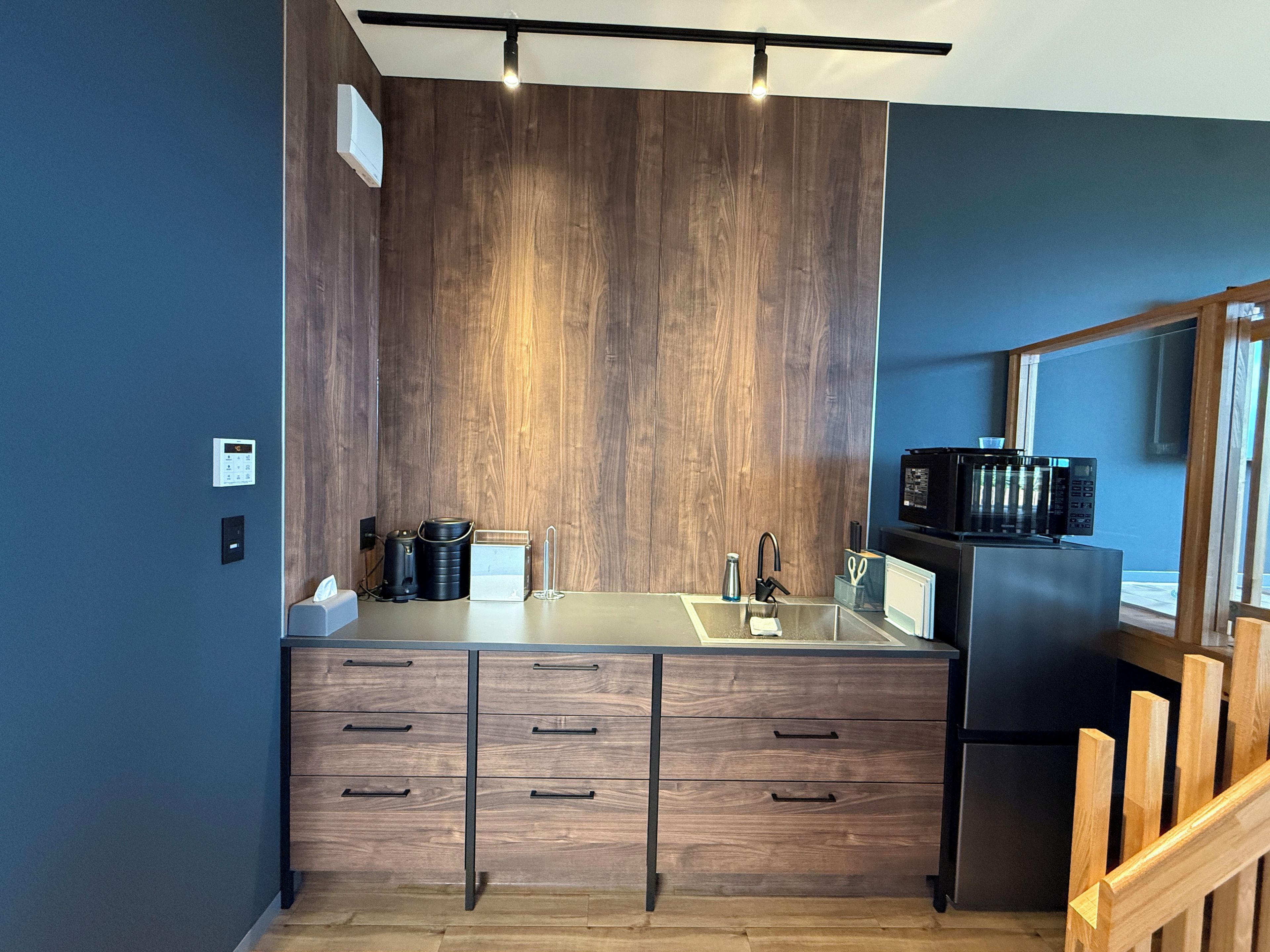 Une cuisine moderne avec des meubles en bois, un évier et un four à micro-ondes.