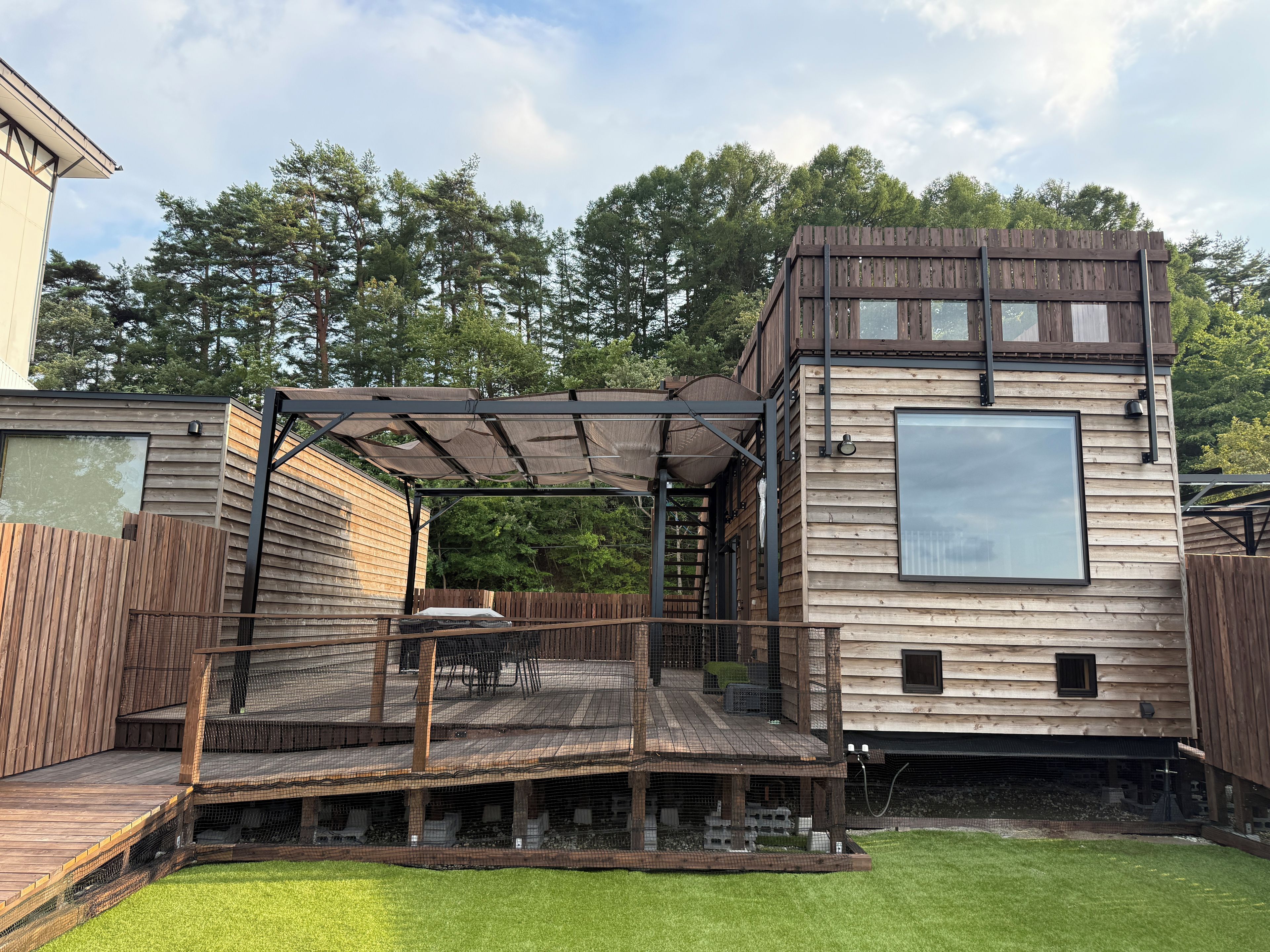 A wooden deck with outdoor seating and a covered area.