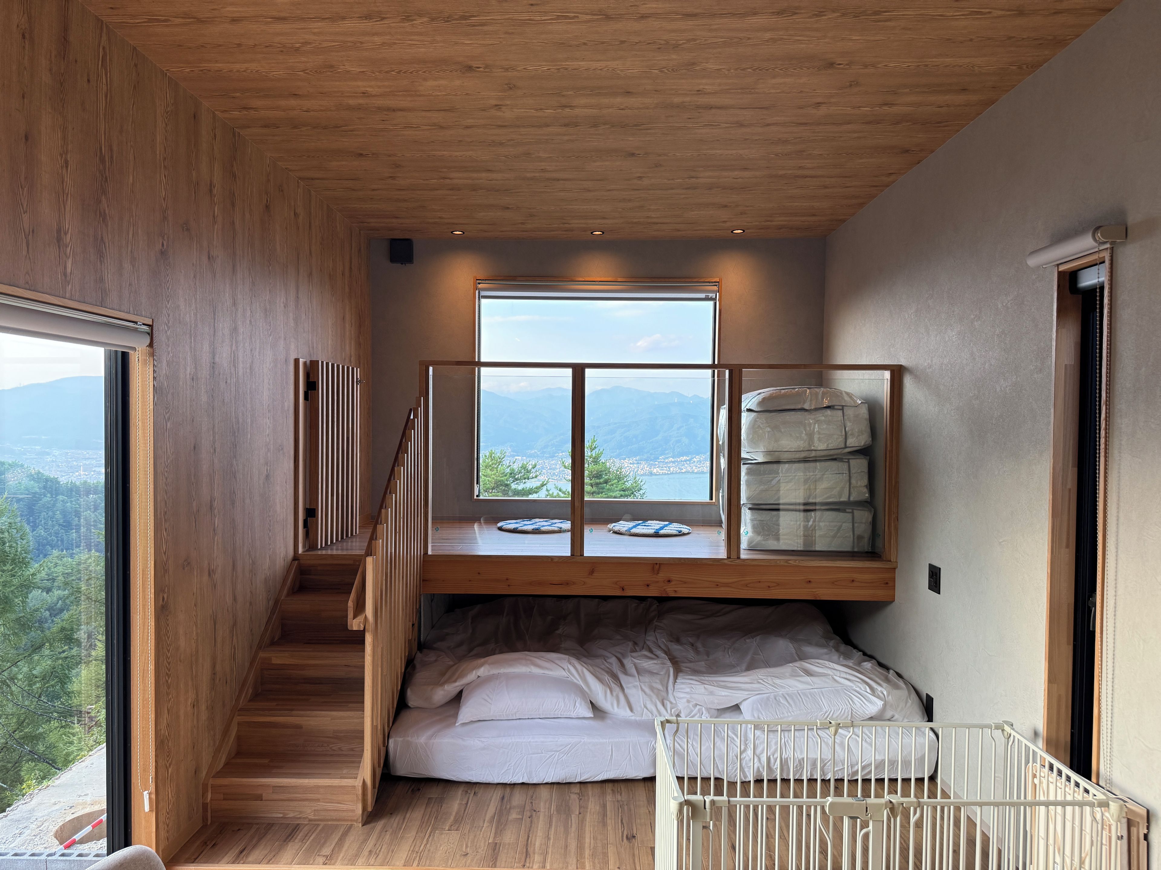 A room with a bunk bed, a view of mountains, and a wooden interior.
