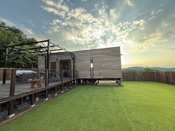 Une maison mobile dotée d’une terrasse et d’un espace clôturé.