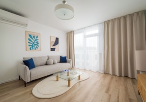 Una sala de estar moderna con un sofá, una mesa de centro y obras de arte en la pared.