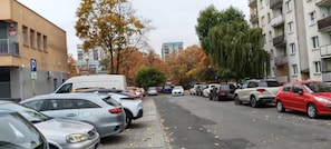 A street view with parked cars, a parking sign, and buildings in the background. - Głogów Comfort Stay Apartament (Głogów)