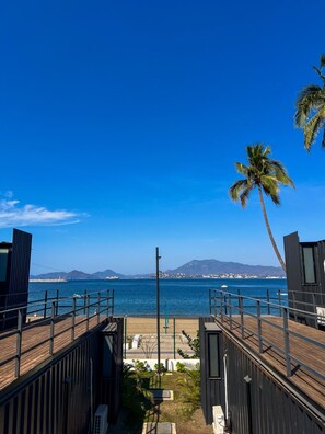 A wooden deck with a view of the ocean and mountains.