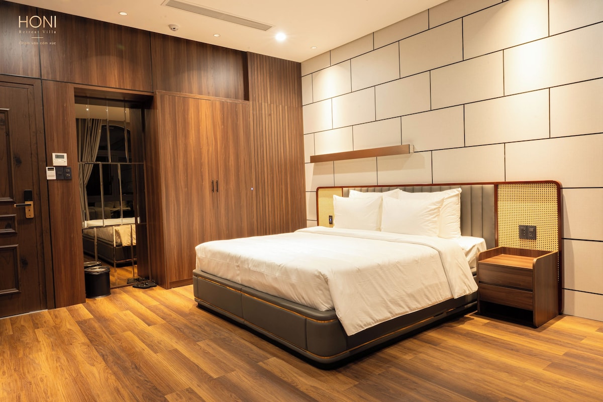 Ein modernes Schlafzimmer mit einem großen Bett, Holzboden und einer integrierten Garderobe.