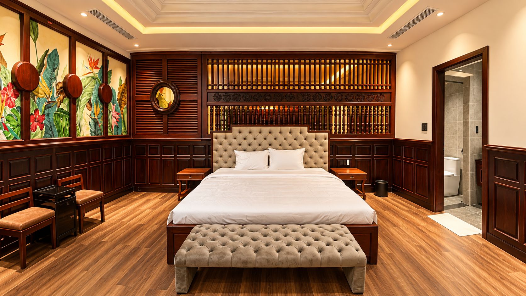 Um quarto espaçoso com uma cama grande, um banquinho, uma mesinha e um relógio fixado na parede.