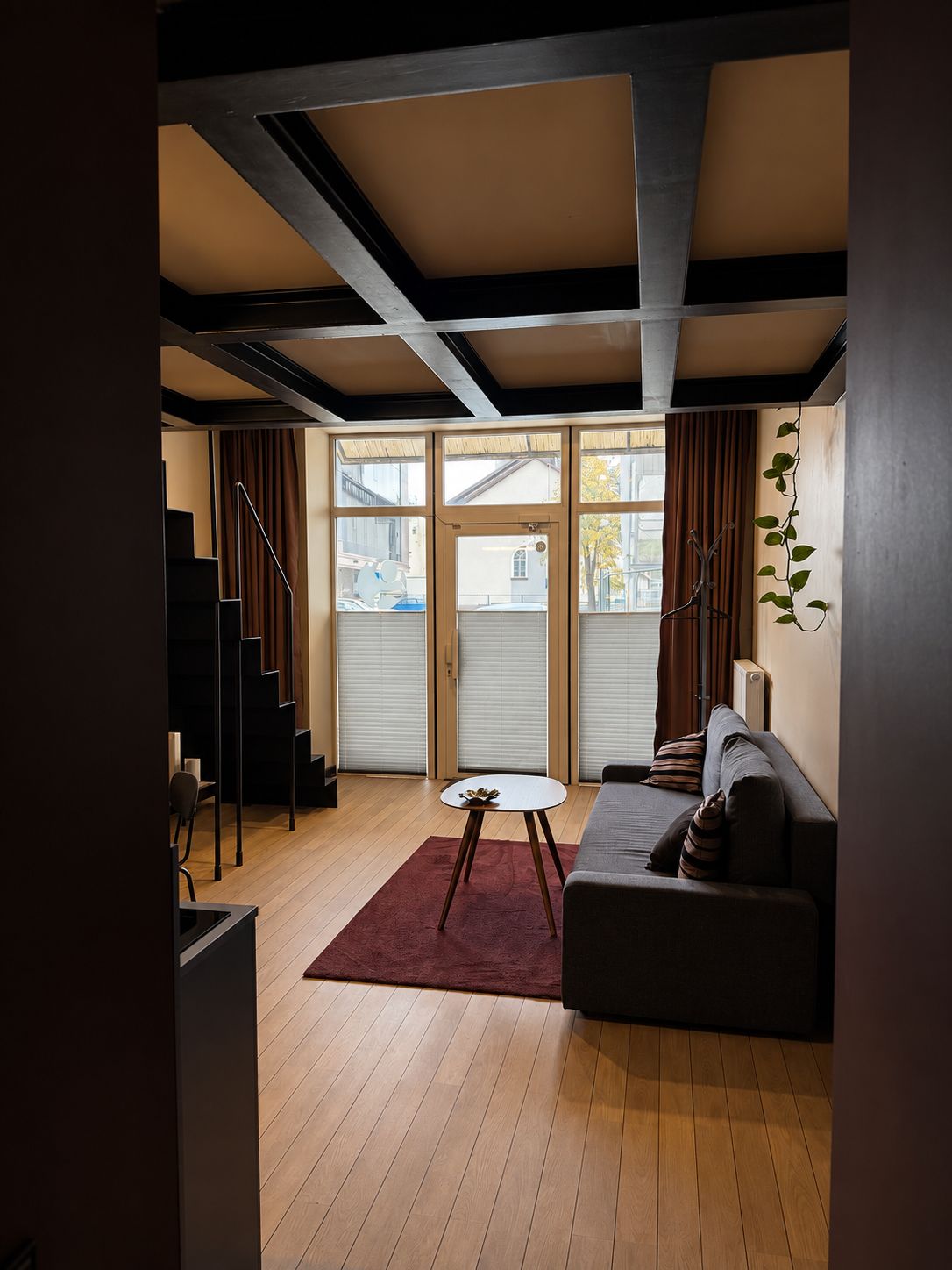 A modern living room with a sofa, a coffee table, and a staircase.