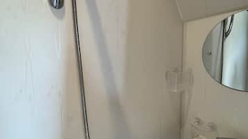 Ein Badezimmer mit Dusche, Waschbecken und Spiegel.