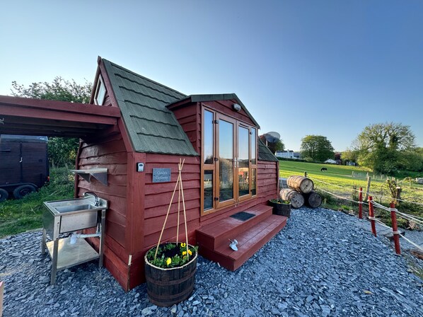 A rustic cabin with a metal sink and a sign reading 'Guide's Getaway'.