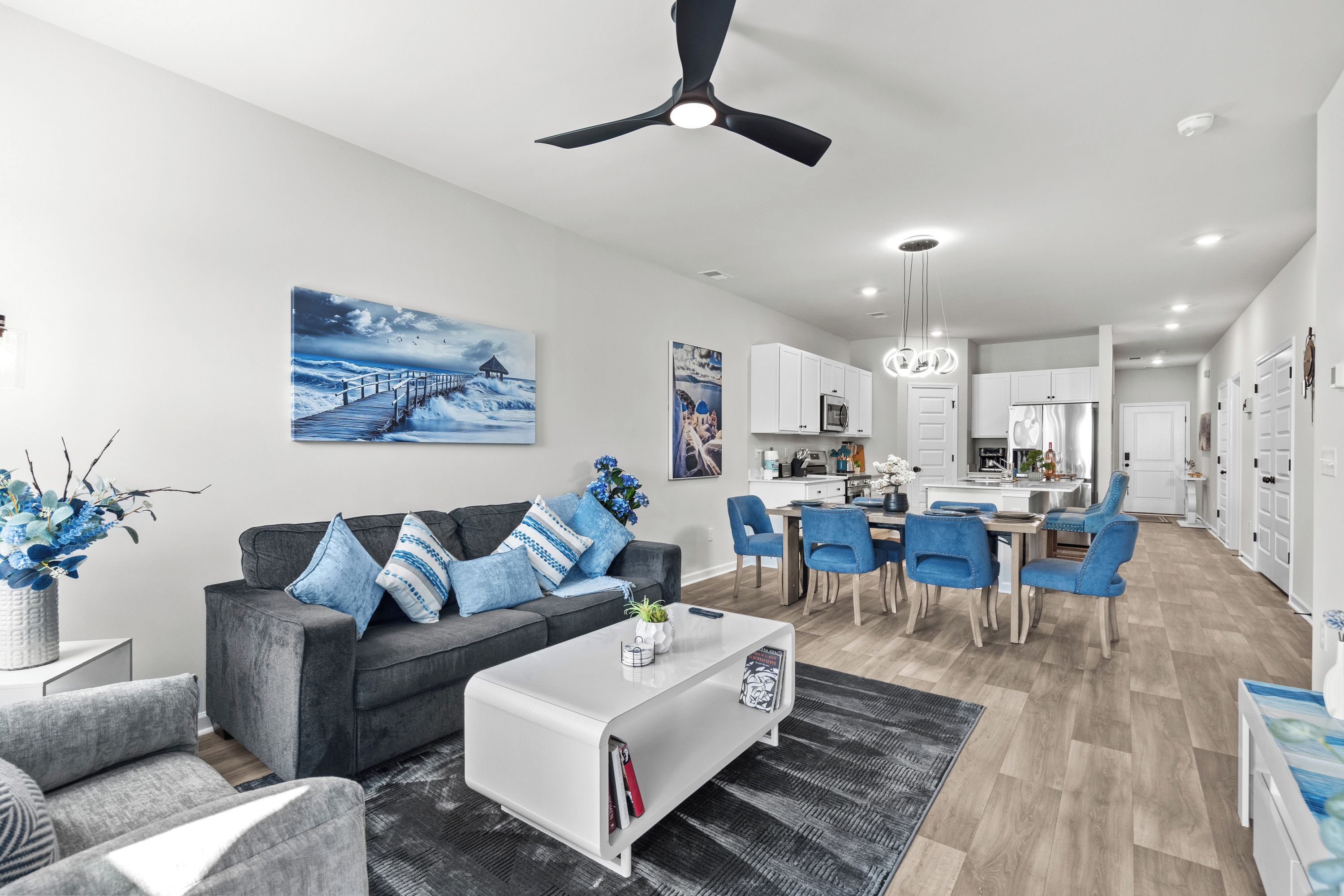 A modern living room with a grey sofa, blue cushions, and a coffee table.