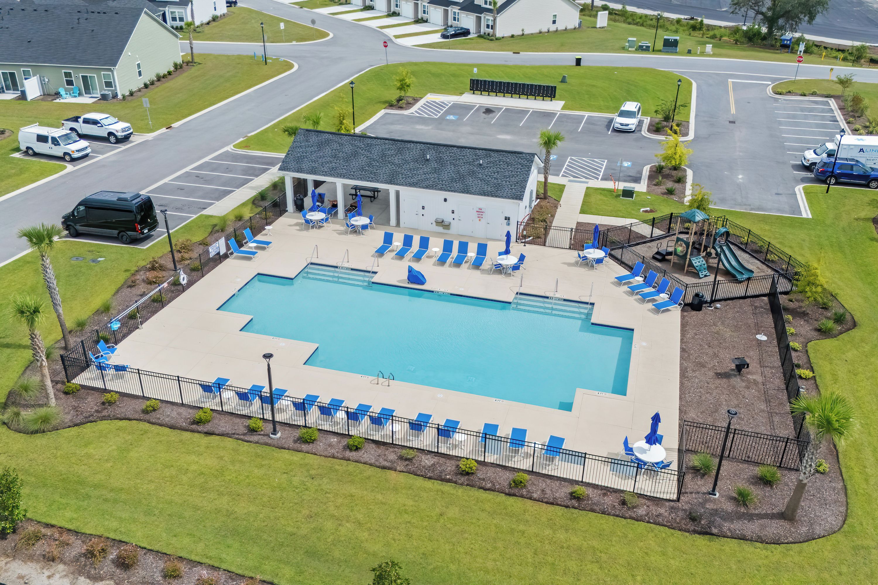 A swimming pool with lounge chairs and a children's play area.