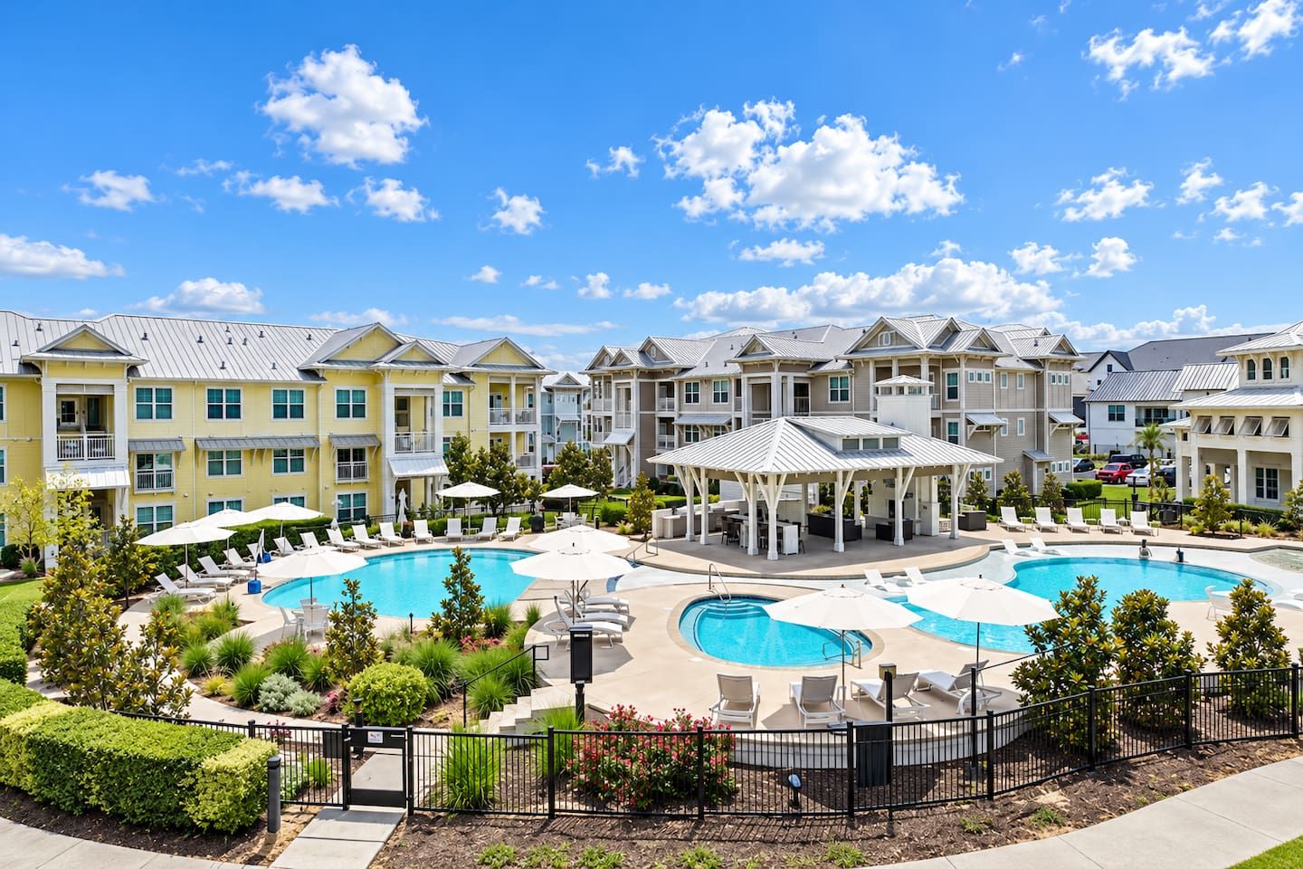 A resort with multiple swimming pools, outdoor seating areas, and a covered pavilion.