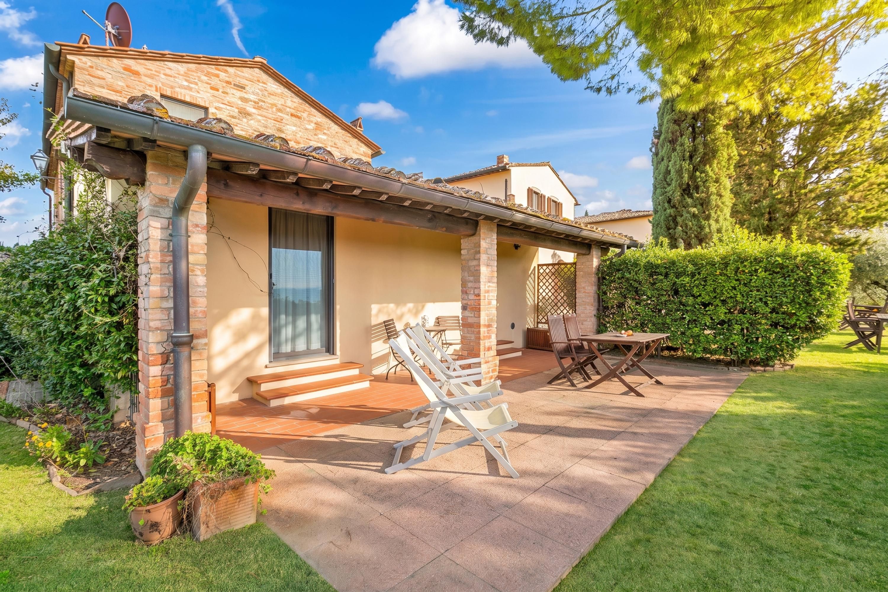 A house with a patio, outdoor furniture, and a well-maintained garden.
