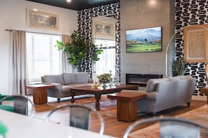 A modern living room with a fireplace, two sofas, a coffee table, and a television. - Lakeside Lakehouse & Bunkbed Cabin, Pool, Dock, Gameroom/All king beds &own bath (Spicewood)