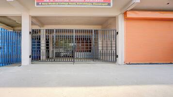 A gated entrance to a building with a sign indicating AC & Non-AC rooms available.