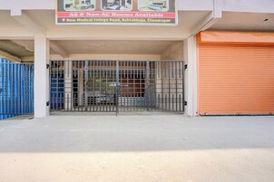 A gated entrance to a building with a sign indicating AC & Non-AC rooms available.