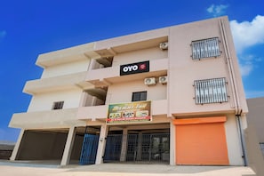 A multi-story hotel with balconies, air conditioning units, and a sign advertising AC & Non-AC rooms. - Hotel O DELIGHT INN (Chandrapur)