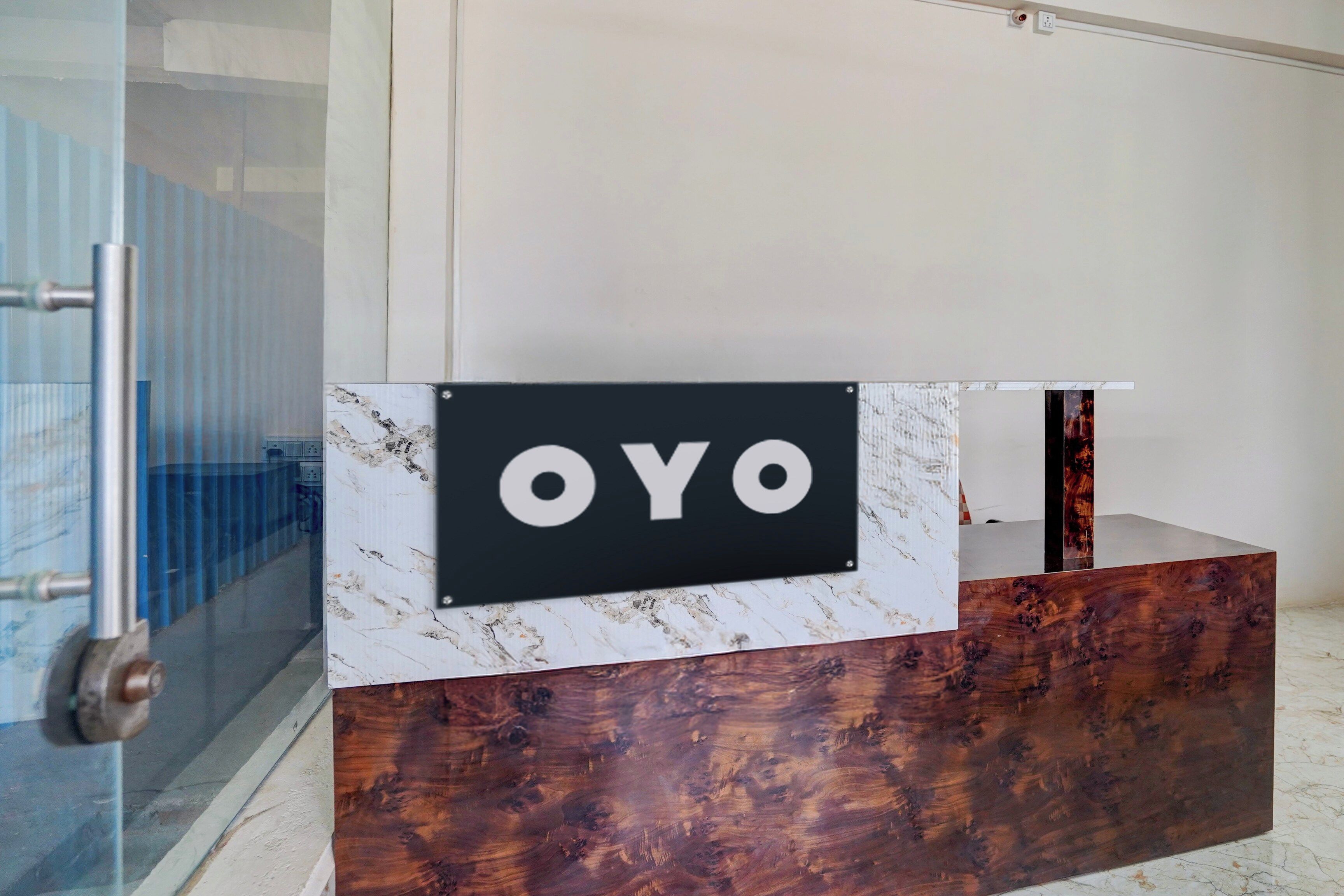 A reception desk with a marble top and a black panel displaying the text 'OYO'.