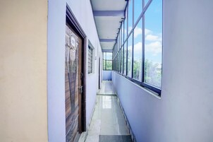 Un pasillo con una puerta marcada '101' y una pared con ventanas.