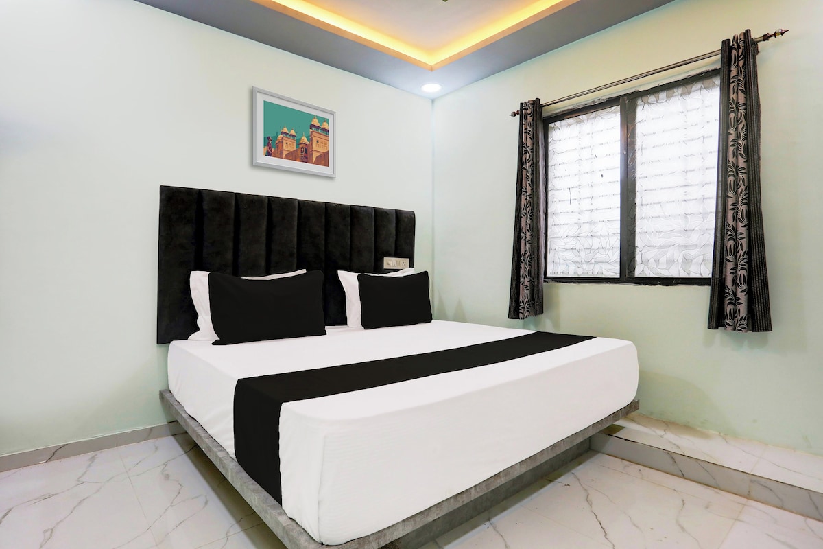 Un dormitorio con cama, cabecera, ventana con cortinas e imagen colgada en la pared.