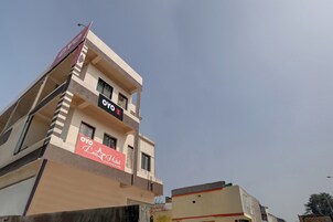 Un edificio de hotel con un letrero que dice 'OYO Leo Hotel' y un letrero que dice 'OYO House & Lodge'.