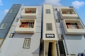 A multi-story building with balconies, a visible entrance, and a sign reading 'OYO'. - Hotel O by OYO MM Home Stays (Coimbatore)