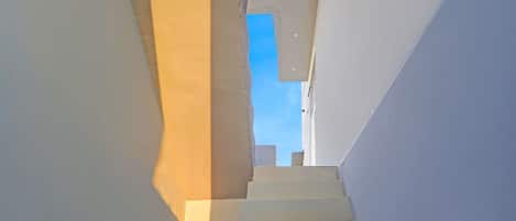 A staircase leading upwards with a clear view of the sky above.