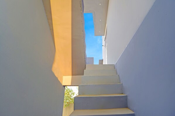 A staircase leading upwards with a clear view of the sky above.