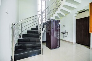 A staircase with metal railings and a black refrigerator with decorative stickers. - Hotel O Aruthraa Residency (Coimbatore)