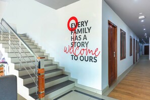 A staircase with a handrail and a wall with a welcoming message. - Collection O Marhaba Govindapuram (Kozhikode)