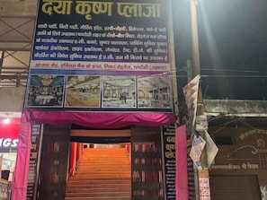 A hotel entrance with a signboard displaying amenities and services. - Hotel O Daya krishna plaza (Chandausi)