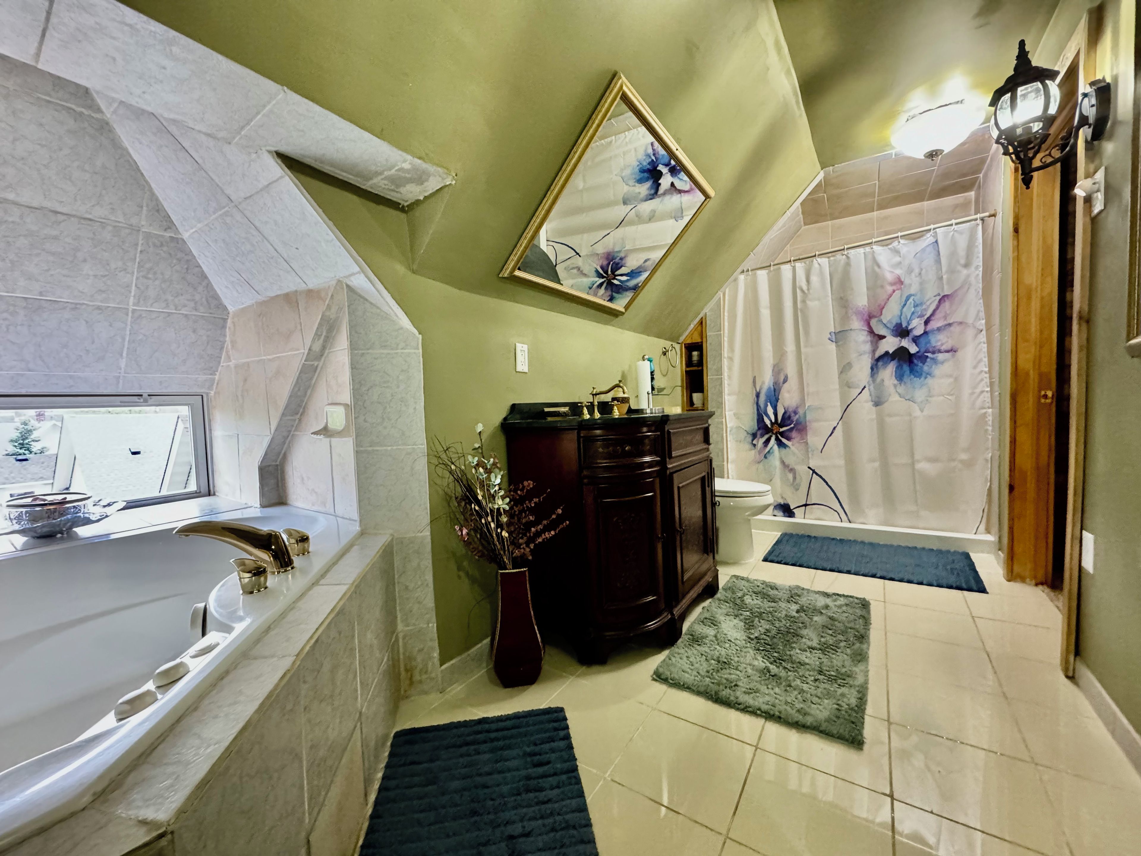 A bathroom with a bathtub, a toilet, a sink, and a shower curtain with floral design.