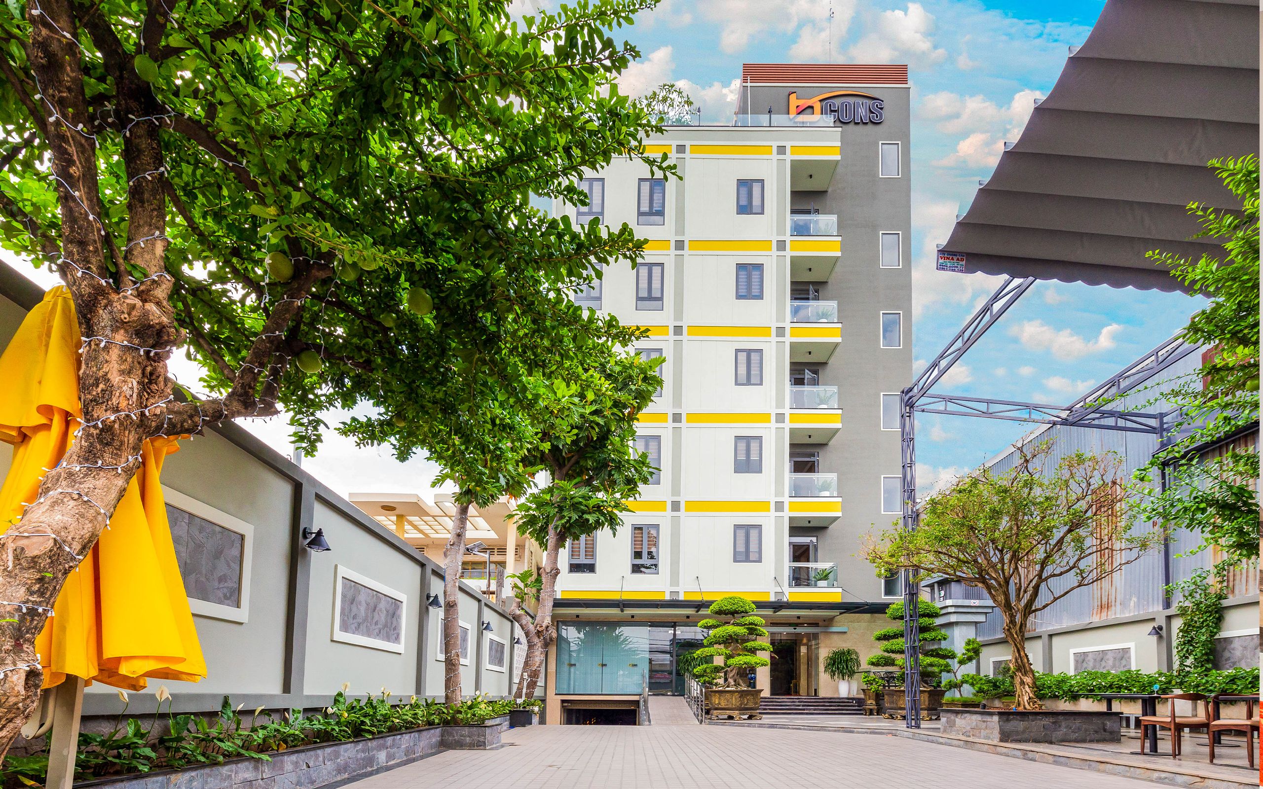 A multi-story building with a modern design, featuring balconies and a central entrance.