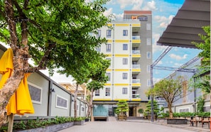 A multi-story building with a modern design, featuring balconies and a central entrance. - Bcons PS hotel (Tam Hiep)