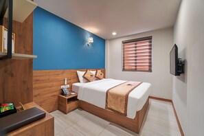 A hotel room with a bed, bedside table, and a wall-mounted TV. - Bcons PS hotel (Tam Hiep)