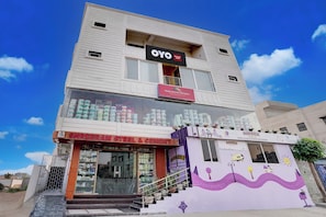 A multi-story building with commercial establishments on the ground floor, including a steel and cement store, a paint store, and a Kidzee preschool. - Hotel O Maheshwari Heights (Cuttack)