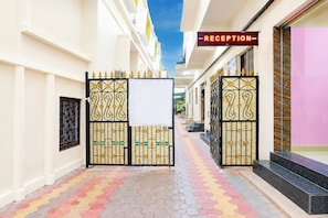 A reception area with a sign, a gated entrance, and a colorful tiled walkway.