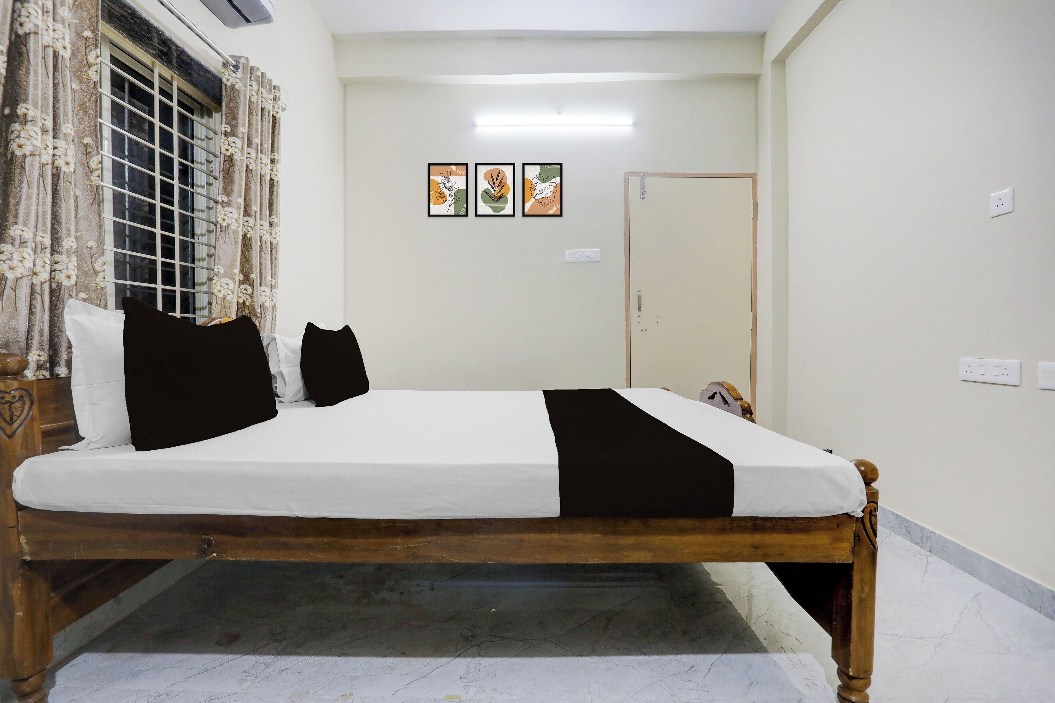 Un dormitorio con cama, cortinas, una puerta y una obra de arte en la pared.