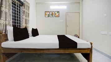 Un dormitorio con cama, cortinas, una puerta y una obra de arte en la pared.