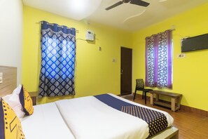 A room with a bed, a chair, a desk, and a ceiling fan. - Hotel O by OYO Prabir Residency Inn (Cuttack)