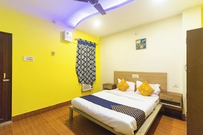 A hotel room with a bed, bedside tables, a ceiling fan, and a window with curtains. - Hotel O by OYO Prabir Residency Inn (Cuttack)