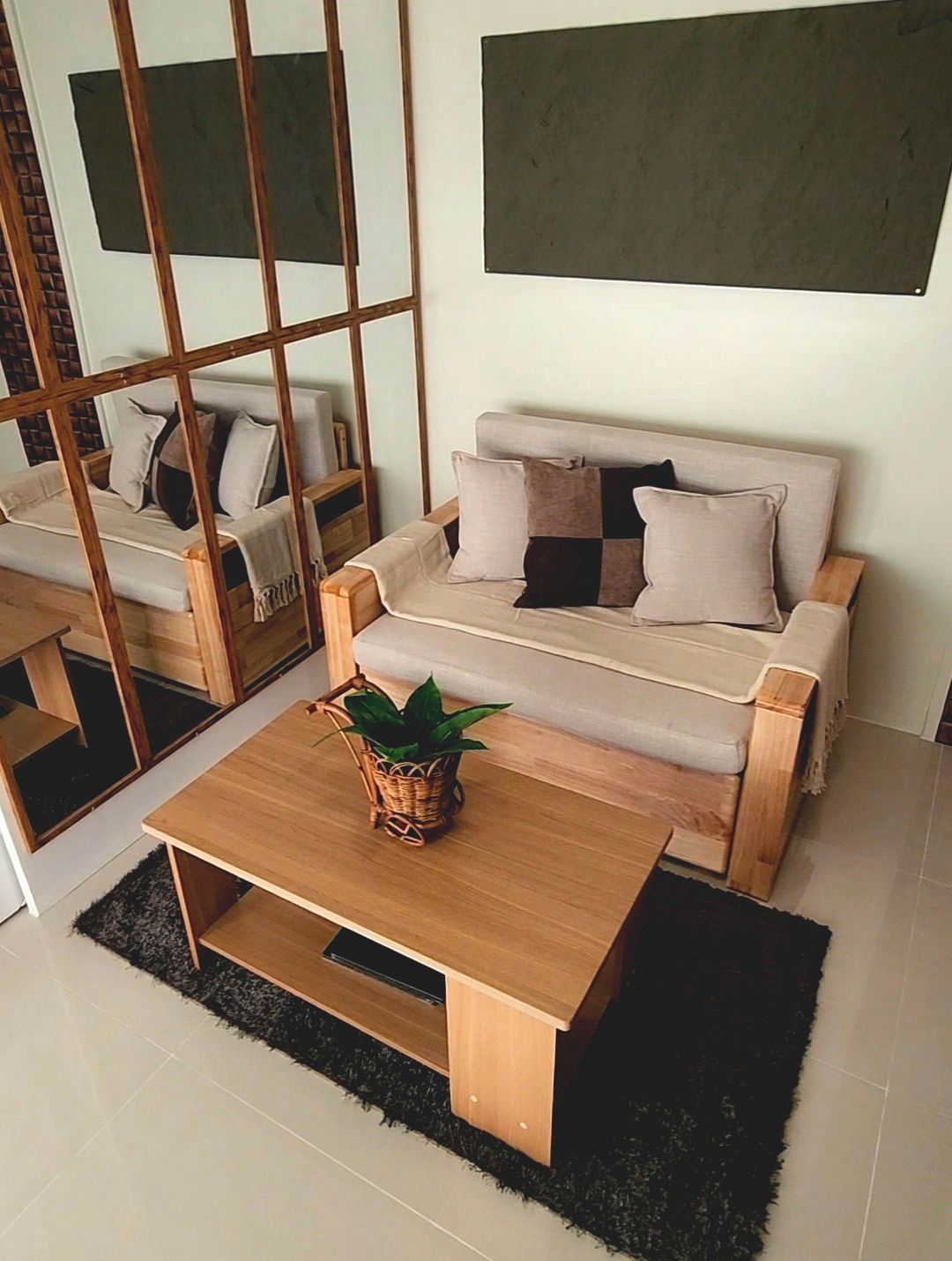 Uma sala de estar moderna com um sofá, uma mesa de centro e uma janela grande.