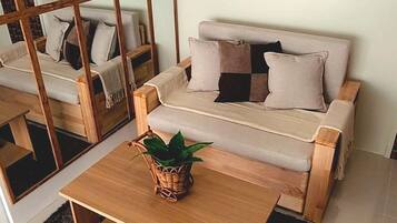 Uma sala de estar moderna com um sofá, uma mesa de centro e uma janela grande.