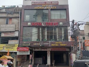 A building with multiple signs, including 'Royal Treat Restaurant & Hotel' and 'Learning Tree India.'