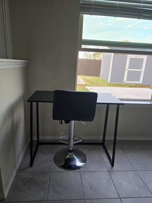 A corner room with a window, a black chair, and a tiled floor. - 3-bedroom house Oasis of calm, in safe neighborhood of Killeen. Airport area. (Killeen)