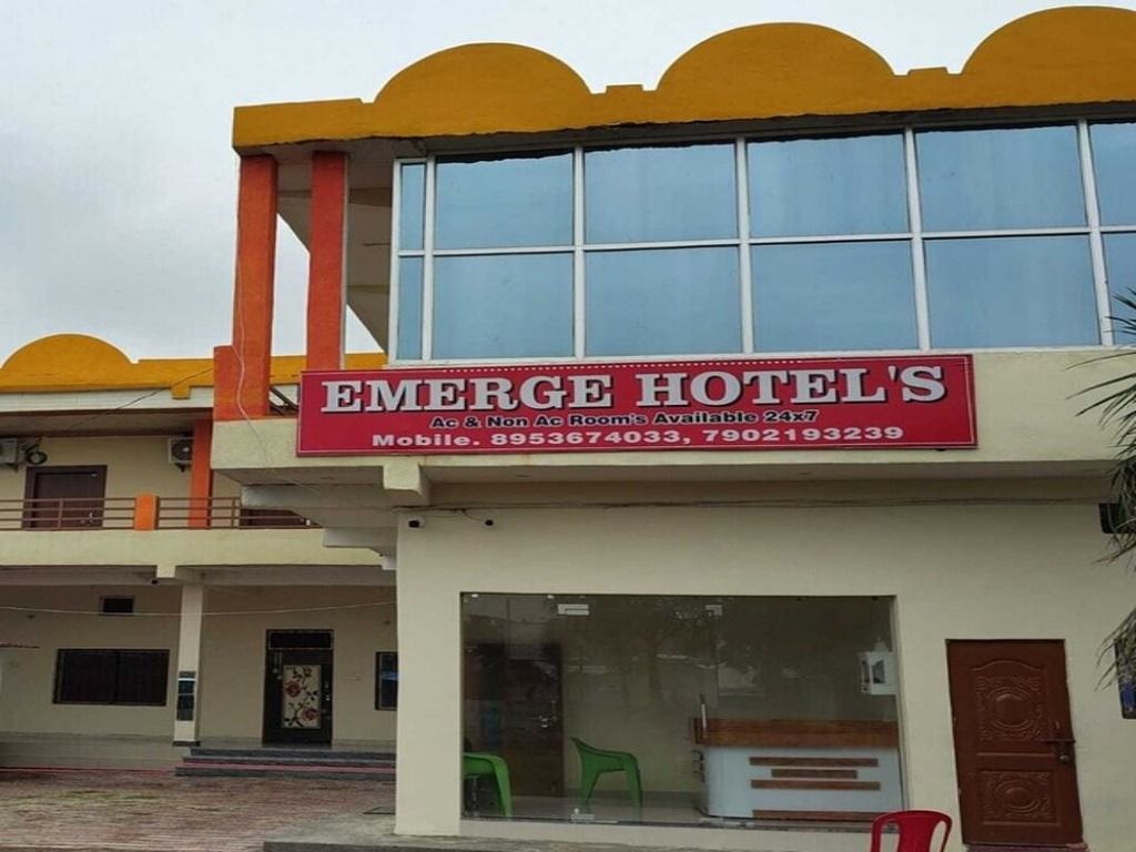 Ein Hotel mit einer roten und weißen Schautafel, auf der der Name 'EMERGE HOTELS' und Kontaktdaten stehen.