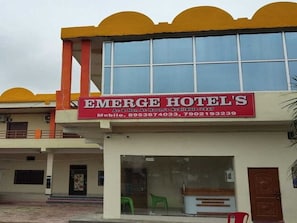 A hotel with a red and white signboard displaying the name 'EMERGE HOTELS' and contact numbers. - Hotel O EMERGE HOTELS (Chitrakoot)