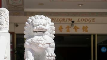 Una estatua de león de piedra frente a un edificio con un letrero que dice 'PILGRIM LODGE'.
