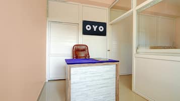 Una habitación con un escritorio, una silla y un cartel que dice 'OYO'.