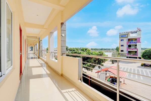A balcony with a view of a parking lot and buildings.