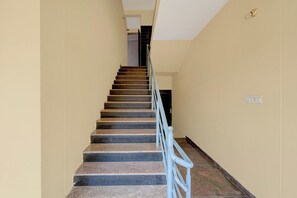 A staircase with a handrail, leading to a door at the top.